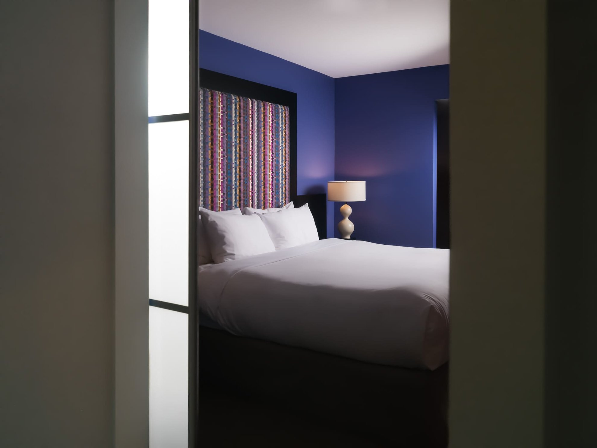 Angled view into a Superior King room at Opus Hotel