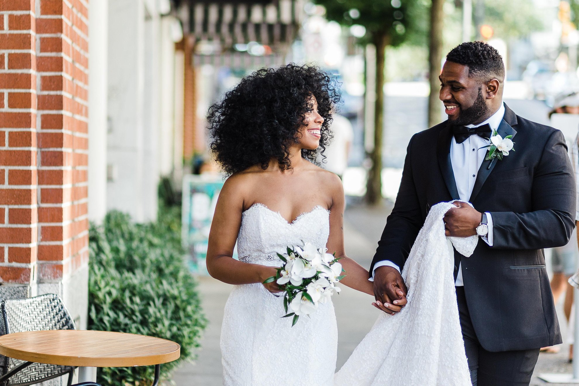 Couple outside bride and groom holding hands outside of OPUS Vancouver